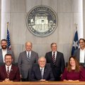 Members of the College Station City Council posed in council chambers beneath the City of College Station seal